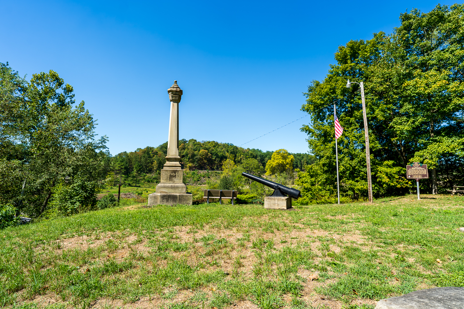 Yellow Creek Monument with Cannon and American Flag in a Scenic Landscape